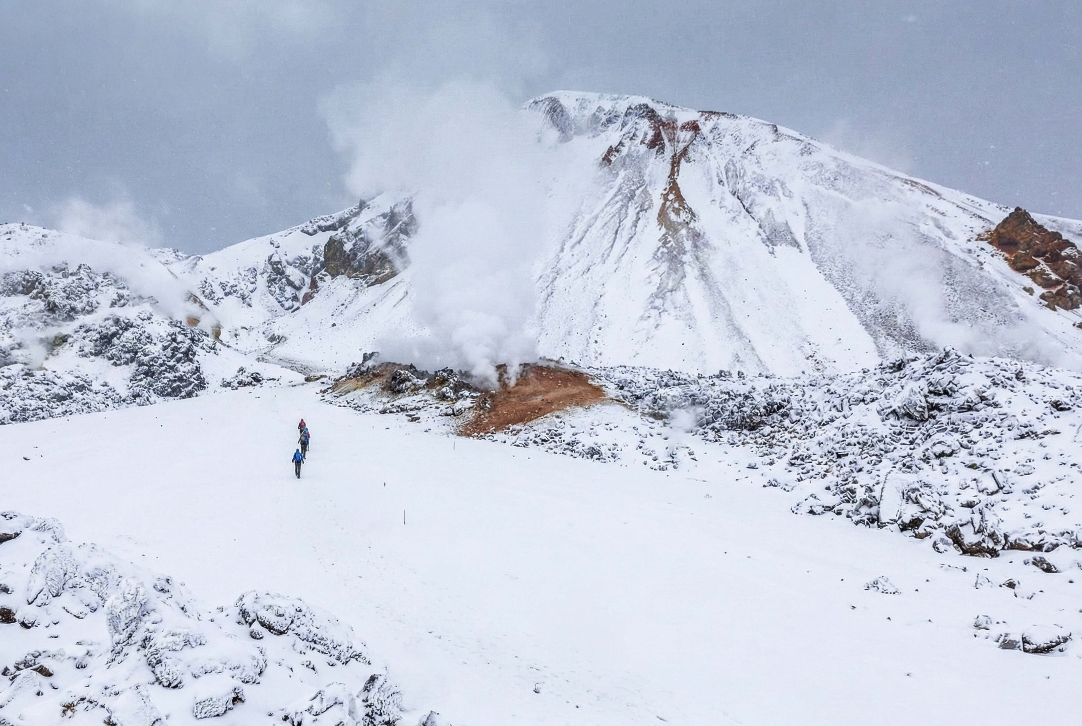 Hikers across snowy lava fields in Landmannalaugar during the winter in Iceland